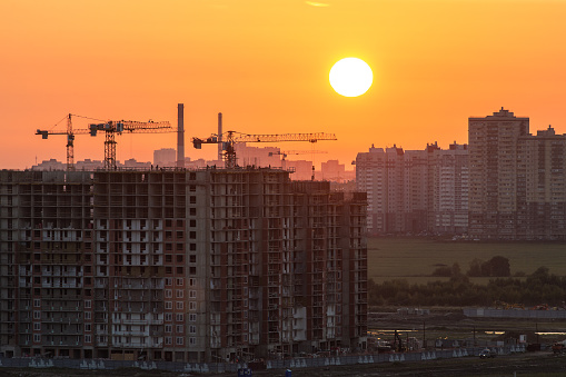 setting sun above the city and the construction site