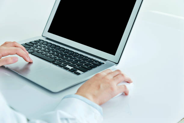 Florence, Italy - May 23, 2015: Close up of an Apple Macbook Pro silver 15 inch on the desk made by wood with the new magic mouse on the right. Apple is one of the leader of technology products on all over the world. Studio shot.