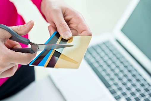 Woman hands cutting credit cards