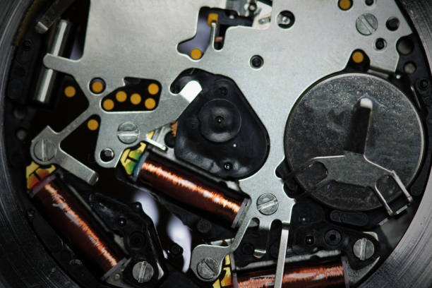 Macro photo of a bourdon tube pressure gauge mechanism with exposed copper elements, isolated on a white background.