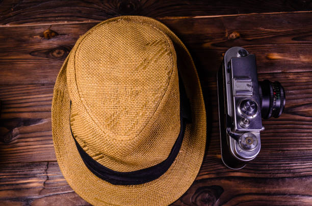 istock Old rangefinder camera and hat on a wooden table. Top view 862560500