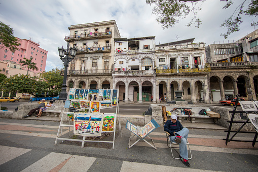 Artists selling their art at the Prado street in La Havana and tourists walking. Prado street is a traditional place for tourists to buy arts and crafts as souvenirs from Cuba