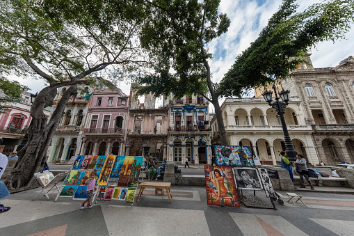 Artists selling their art at the Prado street in La Havana and tourists walking. Prado street is a traditional place for tourists to buy arts and crafts as souvenirs from Cuba