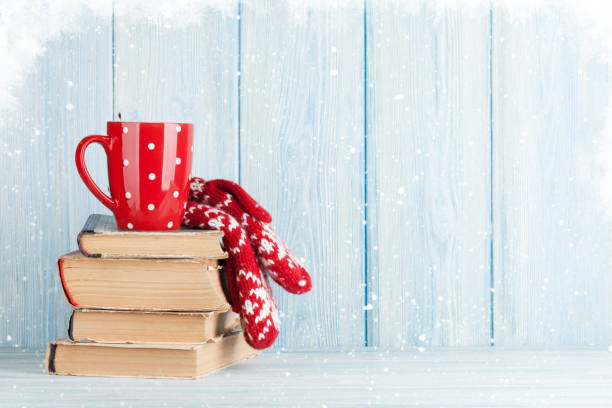 Hot chocolate cup and mittens over books