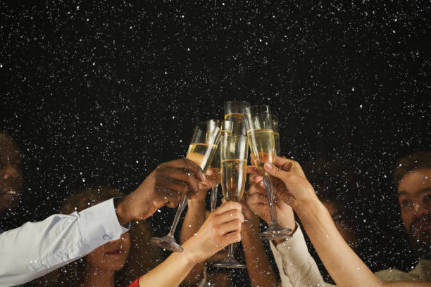 Group of young people celebrating new year with champagne at night club Christmas party time. Young people toasting with champagne flutes. Multiethnic friends congratulating each other with new year. Celebration and nightlife concept, holiday background, selective focus celebratory toast stock pictures, royalty-free photos & images