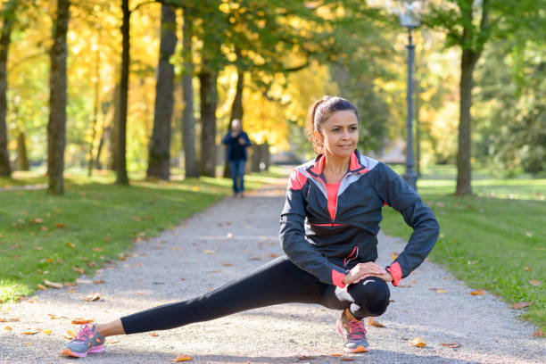 istock Smiling woman stretching in park on sunny day 862578670