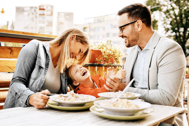 famille bénéficiant de restaurant - child eating pasta spaghetti photos et images de collection