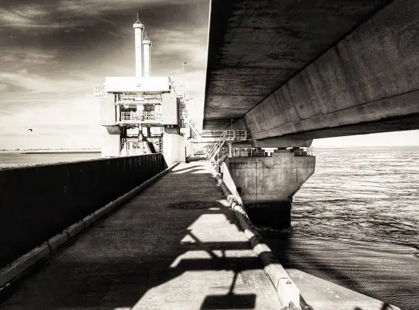 Black and white photo of the Dutch Delta works, a storm barrier landmark  keeping the mainland safe against flooding