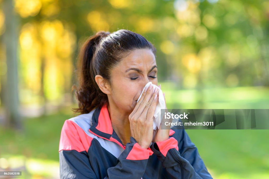 Frau bläst ihr Nase auf einem Gewebe im freien - Lizenzfrei Allergie Stock-Foto