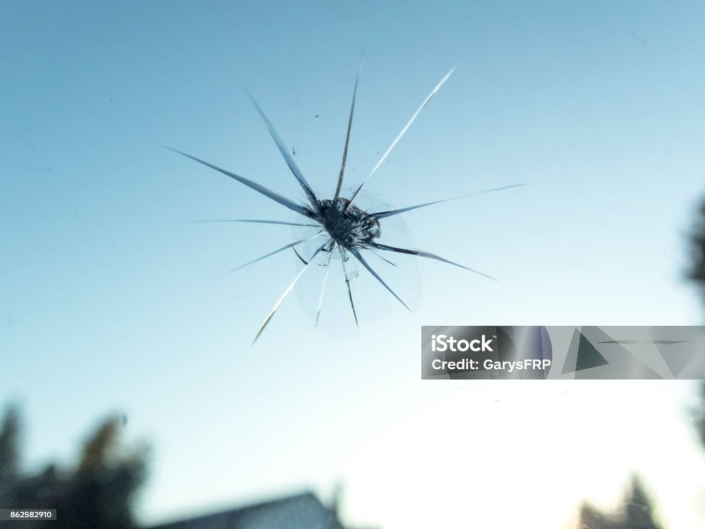 Windshield of Car with Small Rock Chip Close-up from Inside A POV view of a car windshield with a small rock chip as seen from the passenger seat.       Accidents Windshield Stock Photo