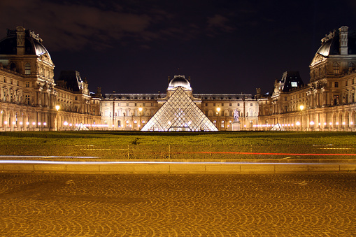 lluminated Louvre museum in Paris. The Pyramid is the main entrance to the Louvre Museum.