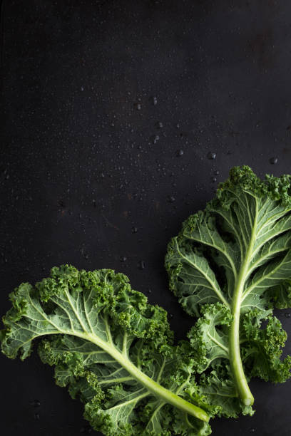 istock fresh green organic kale leaves on dark background 862585478