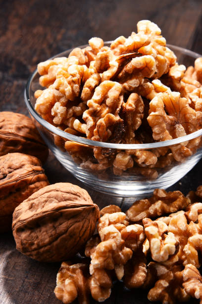 istock Bowl with Persian walnut on wooden table 862589988