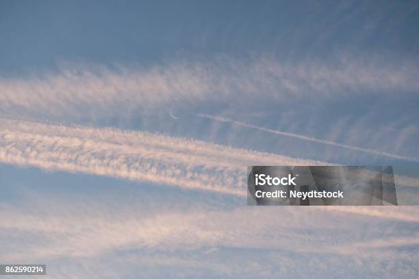 Sunrise Sky With Crossing Contrails And Croissant Of Moon Stock Photo - Download Image Now