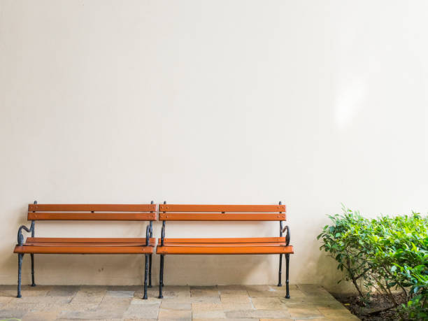 istock Wooden bench and space cream colored wall background 862597108