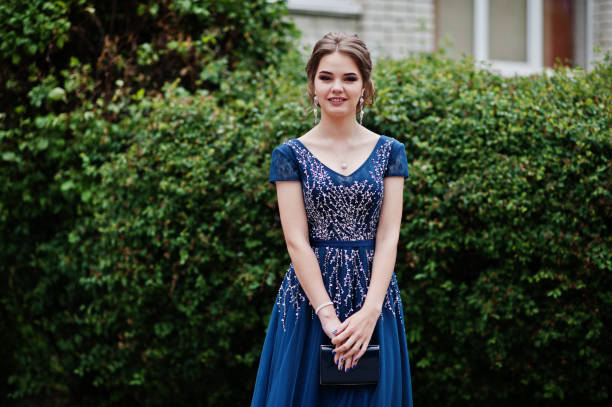 Portrait of a beautiful and gentle girl in elegant gown posing outdoor. Portrait of a beautiful and gentle girl in elegant gown posing outdoor. prom photos stock pictures, royalty-free photos & images