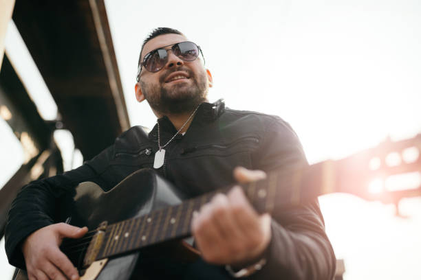 istock Young man playing guitar outdoors 862601668