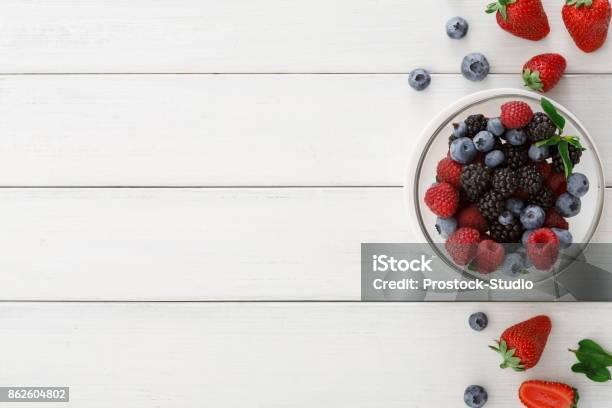 Mixed Berries In Glass Bowls On White Wooden Table Top View Stock Photo - Download Image Now