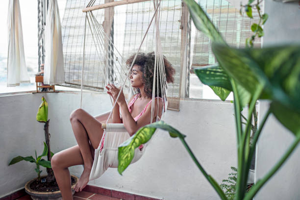 istock Thoughtful young woman sitting on swing at home 862605330