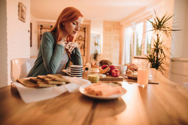 istock Lonely redhead woman thinking about something while having a meal at home. 862605988