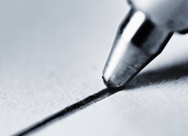 Macro of ballpoint pen tip drawing a line Monochrome macro shot of the roller ball tip of a ballpoint pen drawing a black line. ballpoint pen photos stock pictures, royalty-free photos & images
