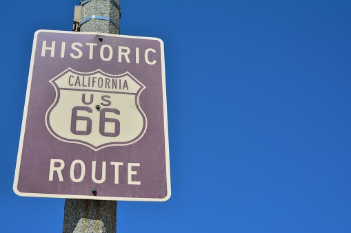 Historic California Route 66 road sign on a blue sky.