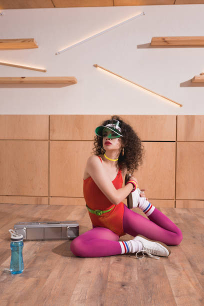 beautiful woman stretching on floor beautiful woman in body suit and cap stretching on floor 80s aerobics stock pictures, royalty-free photos & images