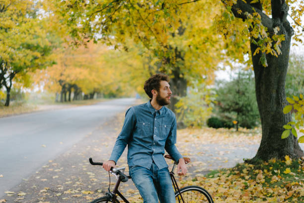 istock Man walking with bicycle under the autumn trees 862625922