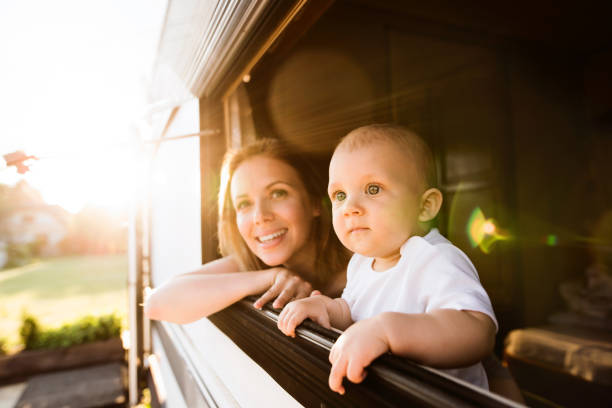 Mother and baby son in a camper van. Beautiful young mother and her baby son in a camper van on a summer day rv travel stock pictures, royalty-free photos & images