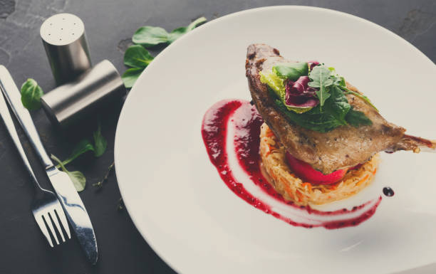 istock Restaurant meals. Duck confit with vegetables on black backgroun 862630064