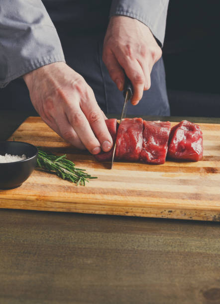 istock Chef cutting filet mignon on wooden board at restaurant kitchen 862632262