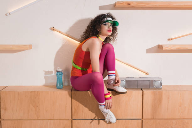 beautiful woman in body suit and cap looking at camera