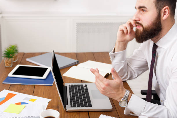 istock Serious businessman talking on cell phone with laptop in modern office 862634834