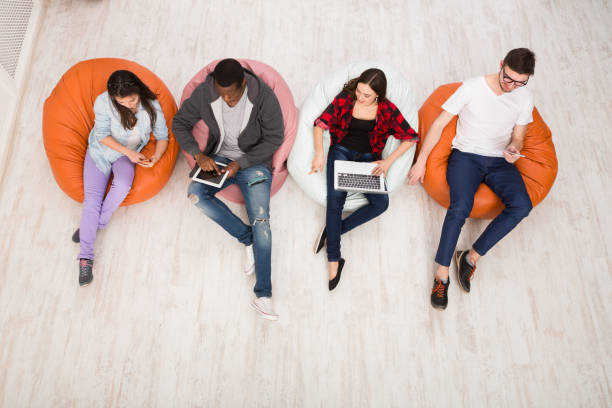 istock Friends using gadgets, sitting indoors in line 862641570