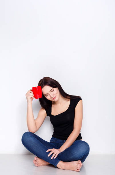 istock Young woman sitting at home floor with coffee cup 862650732