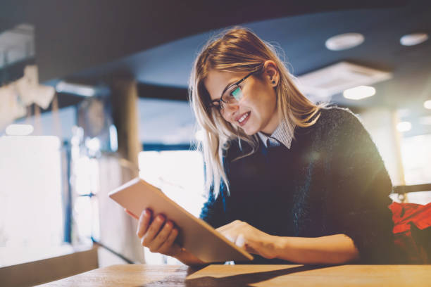 istock Happy young woman using tablet at coffee shop 862650828