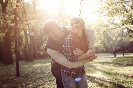 Couple in love standing in park and hugging.