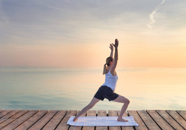 istock Young woman practicing yoga by sea 862663916