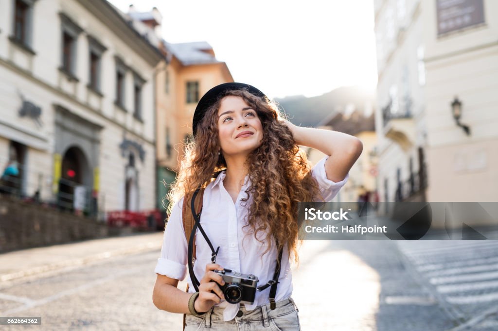 Young tourist with camera in the old town Beautiful young tourist with camera in the old town Tourist Stock Photo