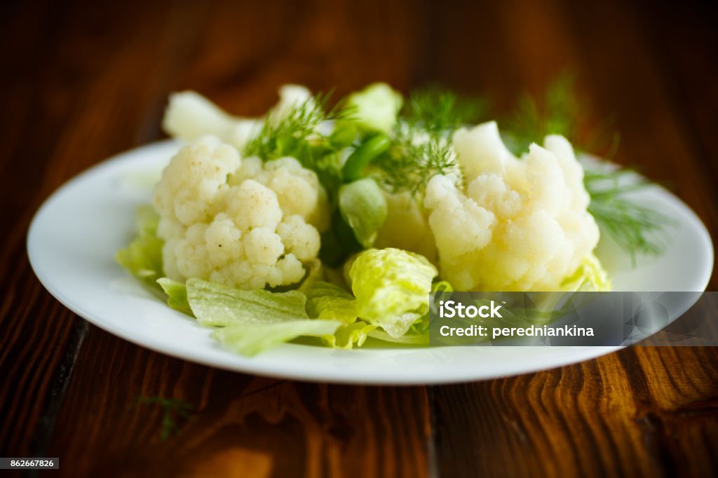 cauliflower with salad leaves cauliflower with salad leaves on a wooden table Appetizer Stock Photo