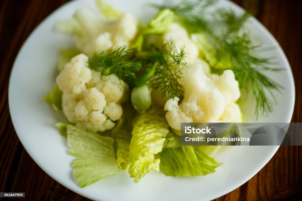 cauliflower with salad leaves cauliflower with salad leaves on a wooden table Appetizer Stock Photo