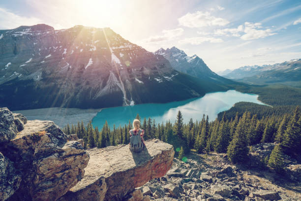 Young woman hiker on top of mountain Young woman hiker on rock above mountain lake in Springtime. People success in nature concept canadian rockies stock pictures, royalty-free photos & images