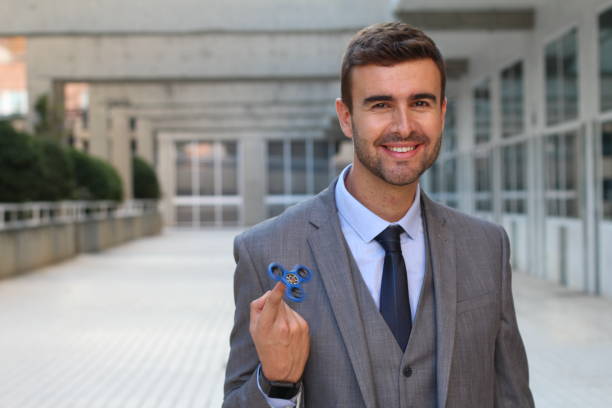 Cute businessman playing with a hand spinner