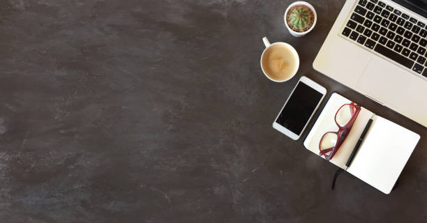 Top view of office desk on dark textured background