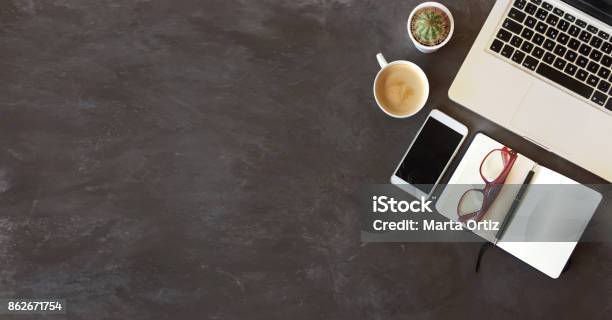 Top View Of Office Desk On Dark Textured Background Stock Photo - Download Image Now