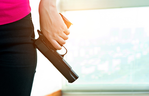 Woman hand holding a gun