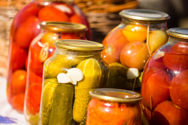 istock canned cucumbers and tomatoes in glass jars 862680116