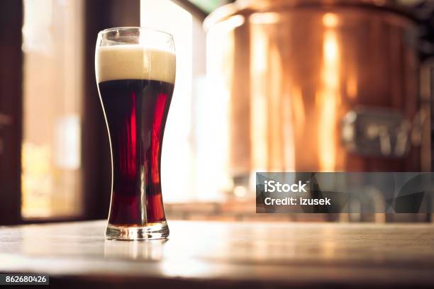 Glass Of Bitter Ale Beer In Front Of Copper Vat Stock Photo - Download Image Now - After Work, Alcohol - Drink, Ale