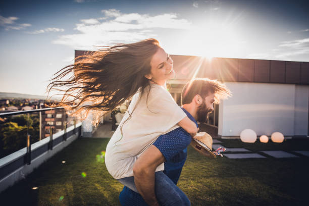 istock Young playful couple piggybacking and having fun on a penthouse balcony. 862680486