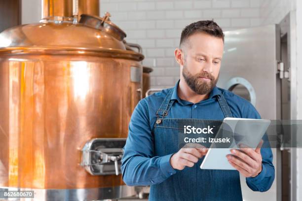 The Master Brewer Using A Digital Tablet In His Micro Brewery Stock Photo - Download Image Now